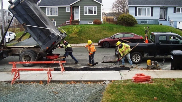 Asphalt business-three men working on street spreading asphalt
