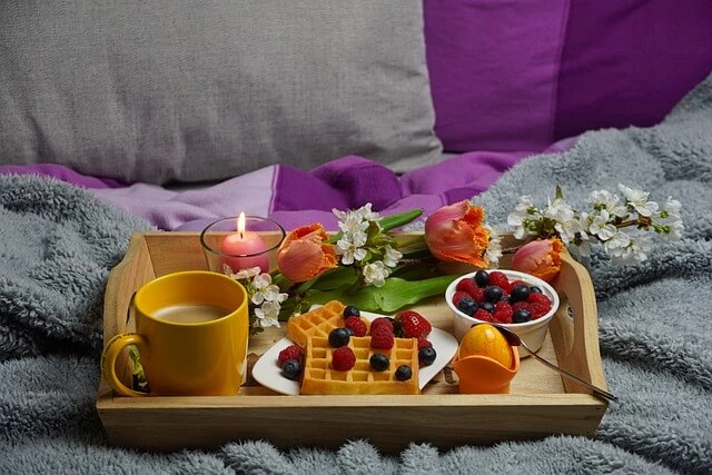 Bed and Breakfast-breakfast tray with waffles, egg, coffee, fruit and burning candle