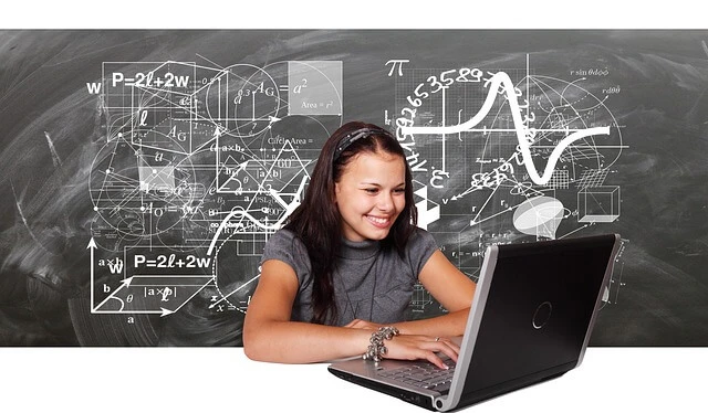 Charter School - young woman with laptop - blackboard with mathematical equations as background