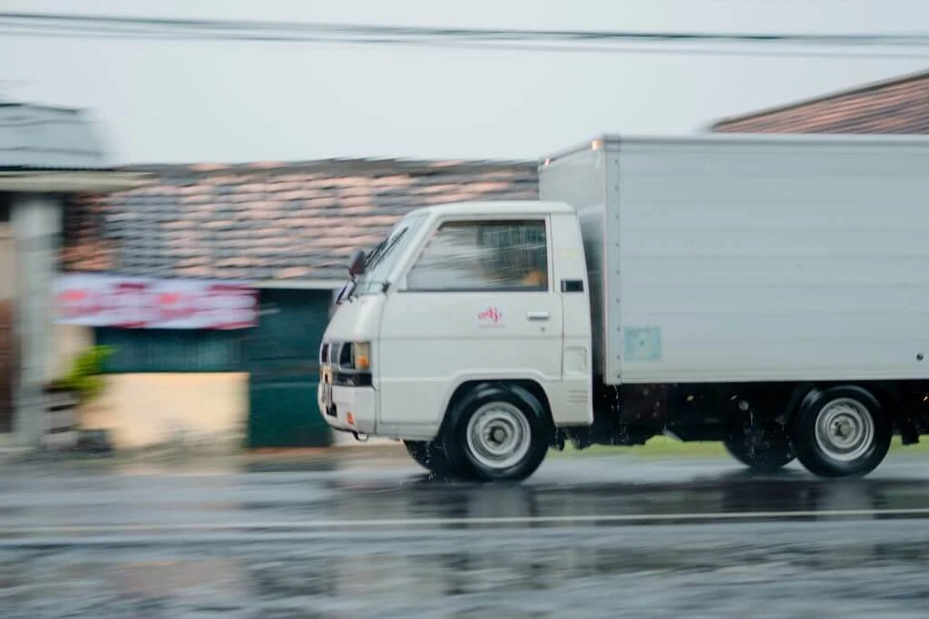 Moving Business-White moving van driving down road