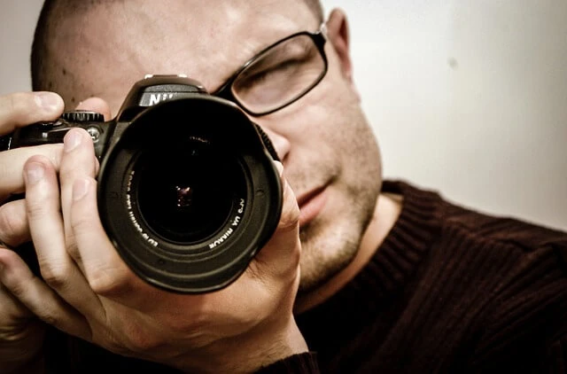 Photography Business-Closeup of photographer holding camera