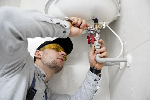 Plumbing Business-Plumber repairing pipes under sink