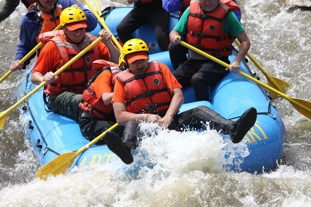 River Guide business-Closeup of raft with five men going through whitewater