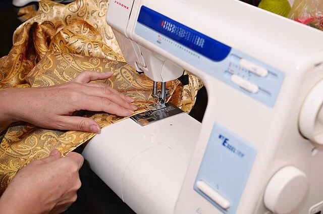 Seamstress Business-woman pushing garment through sewing machine