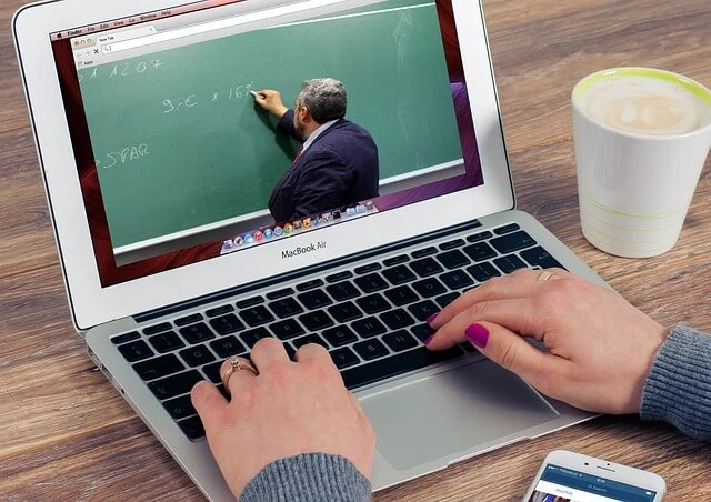 Tutoring business-laptop showing teacher writing math equation on blackboard
