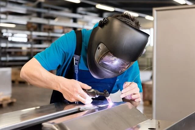 Welding business-welder with protective helmet welding steel