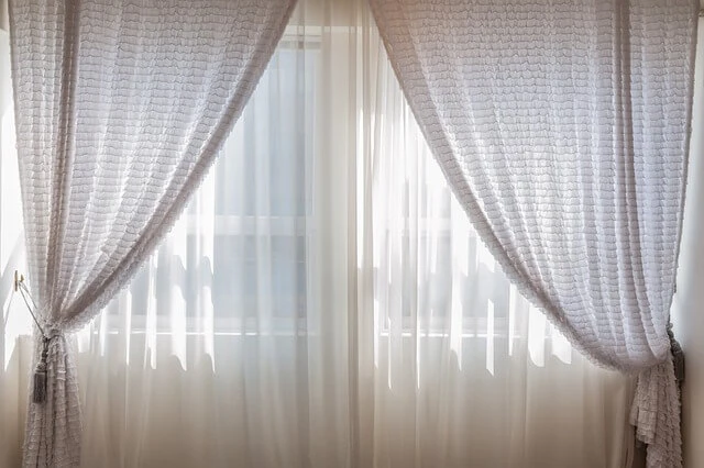 Window Treatments-light-colored sheers and drapes on window