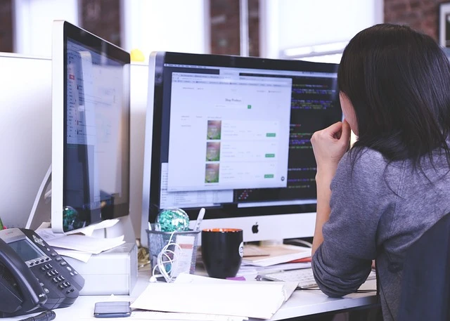 IT Services Business - Woman studying data on monitors